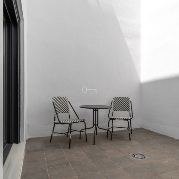 Nowoczesny patio z dwoma krzesłami i małym stolikiem, idealne do relaksu i spotkań.