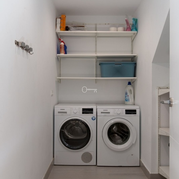 Pralka i suszarka w pralni, praktyczne urządzenia do prania i suszenia odzieży, nowoczesny sprzęt AGD w domu.