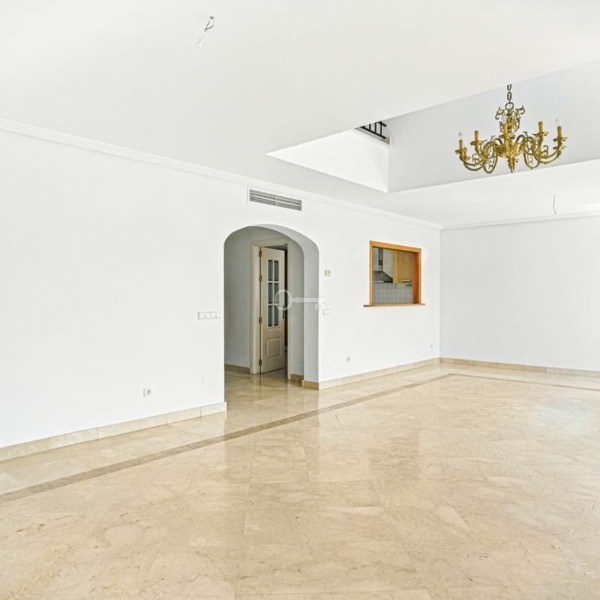 Nowoczesny salon w luksusowym mieszkaniu z eleganckim żyrandolem, idealny dla rodzin i inwestorów.