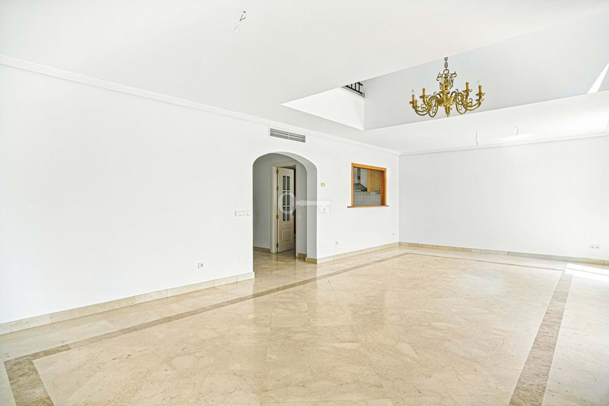 Nowoczesny salon w luksusowym mieszkaniu z eleganckim żyrandolem, idealny dla rodzin i inwestorów.