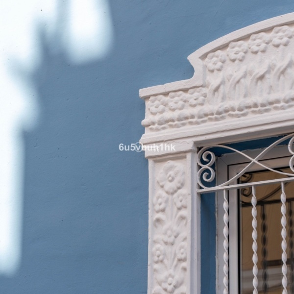 Klimatyczne detale architektoniczne na jasnoniebieskiej ścianie, ozdobiony drewnianym ornamentem.