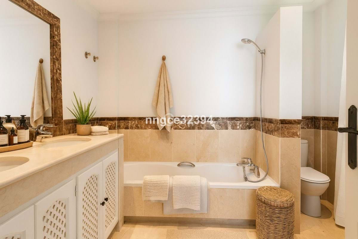 łazienka z wanną, umywalką i toaletą, elegancki design, komfortowe warunki, aranżacja przestrzeni, akcesoria łazienkowe.