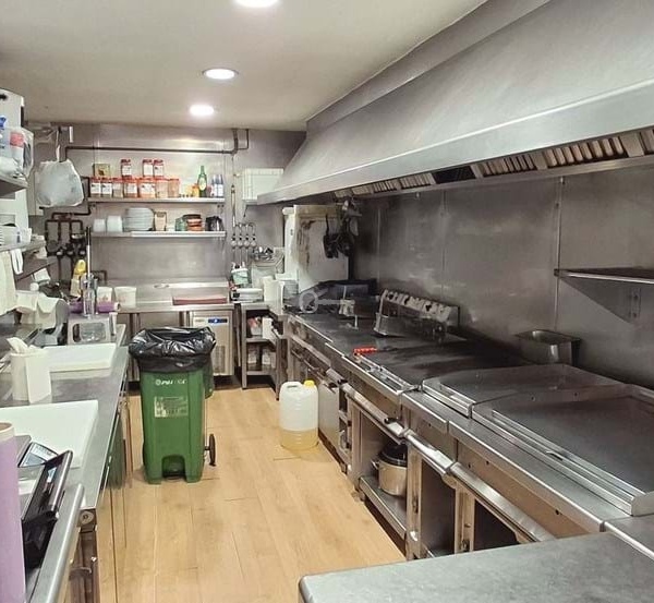 Kuchnia restauracyjna z profesjonalnym sprzętem i warzywkami na zamówienie.