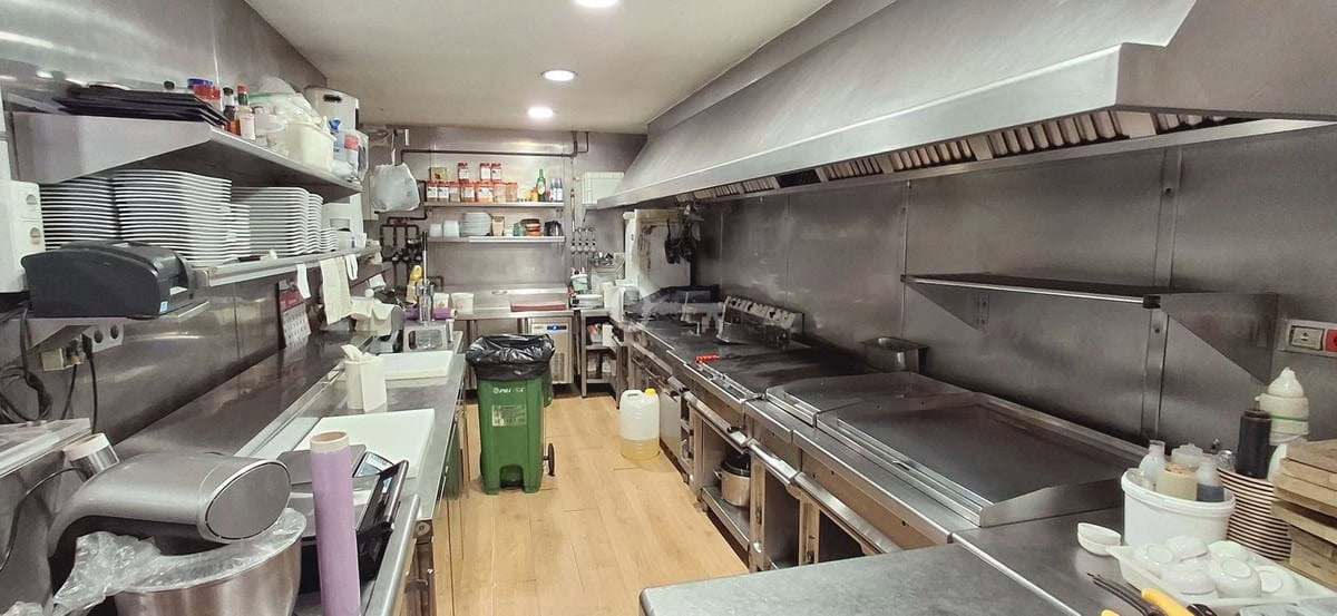 Kuchnia restauracyjna z profesjonalnym sprzętem i warzywkami na zamówienie.